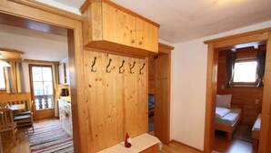 A wooden cabin interior with a dining area, a kitchen, and a sleeping area. - Apartment in Kaltenbach near Ski Lift (Kaltenbach)
