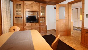 A wooden room with a bed, a television, and a wardrobe. - Apartment in Kaltenbach near Ski Lift (Kaltenbach)
