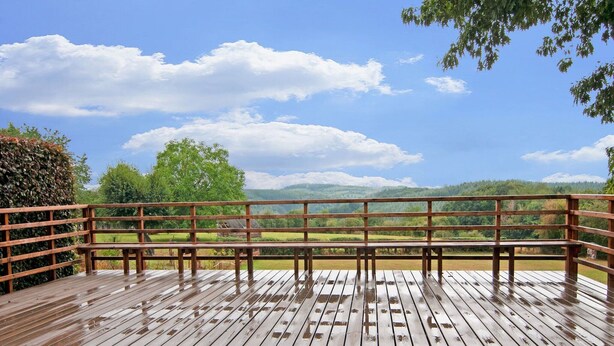 Un pontile in legno con ringhiera che si affaccia su un panorama suggestivo.