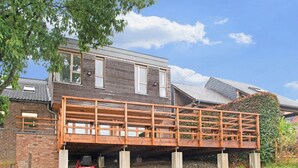 Una casa a due piani con una veranda in legno in fase di costruzione.