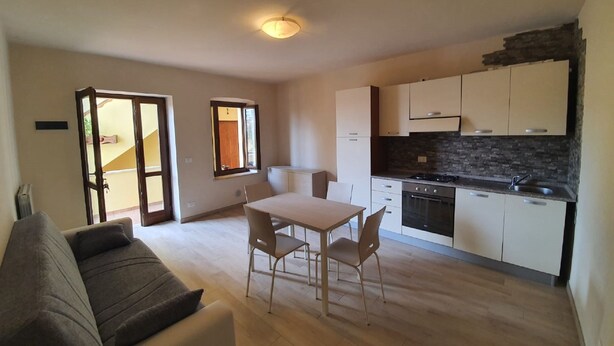 Un apartamento moderno con comedor, cocina y sala de estar con sofá.