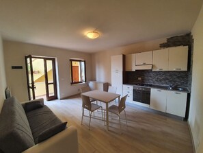 Un apartamento moderno con comedor, cocina y sala de estar con sofá.