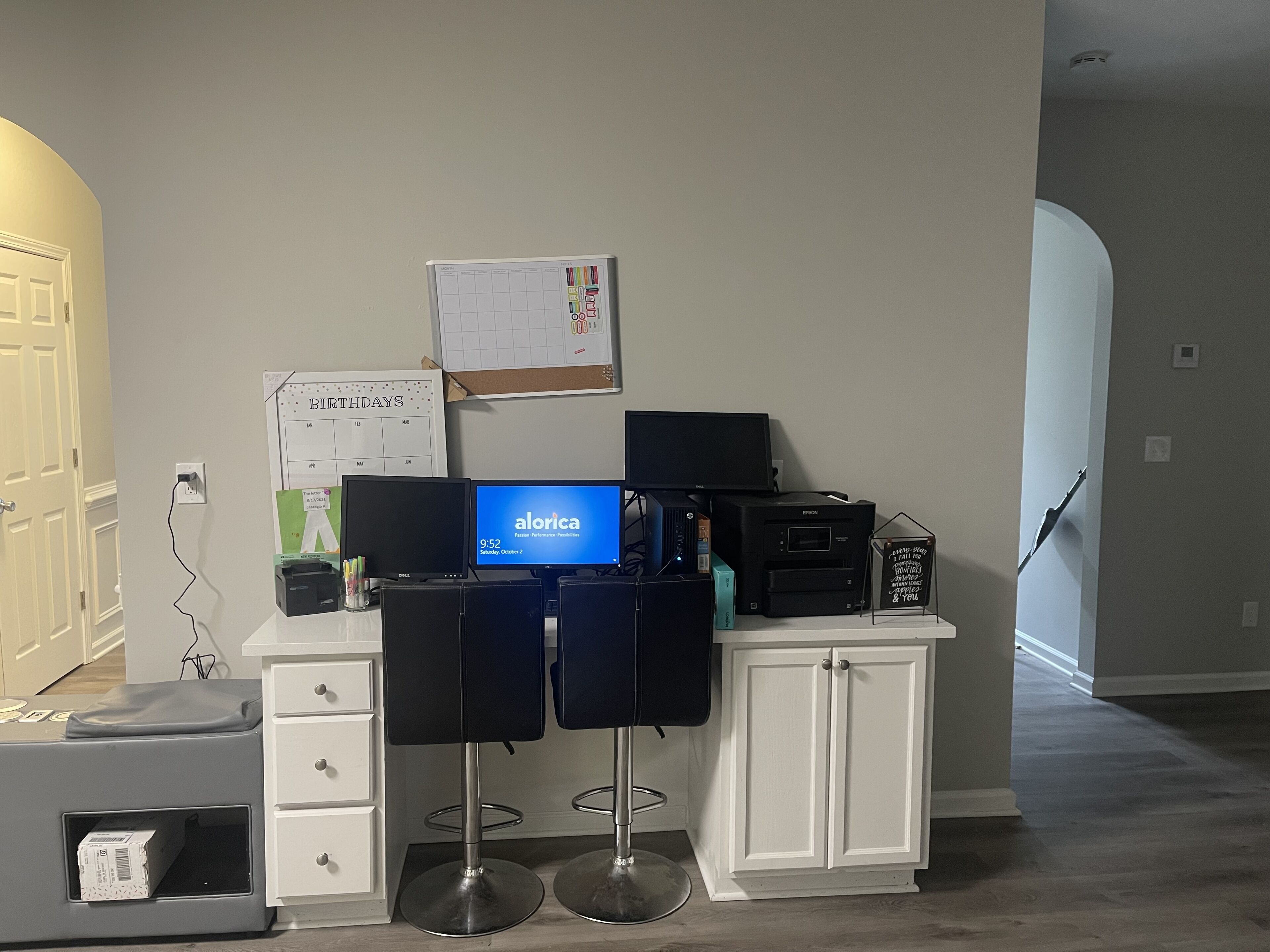 A home office setup with a computer, printer, and desk chairs.