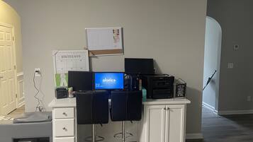 A home office setup with a computer, printer, and desk chairs.