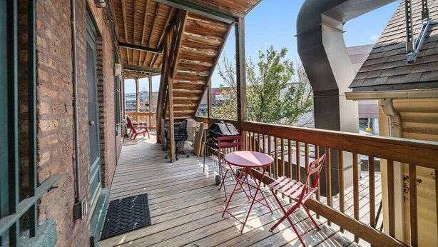 A wooden deck with a railing, outdoor seating, and a grill. - Classic Lincoln Park  2 bedroom condo- parking included (Chicago)