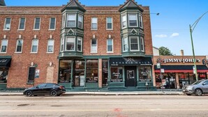 A row of brick buildings with storefronts, including a nail salon and a restaurant. - Classic Lincoln Park  2 bedroom condo- parking included (Chicago)