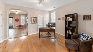 A spacious living room with hardwood flooring, a dark wooden desk, a comfortable armchair, and a bookshelf. - Classic Lincoln Park  2 bedroom condo- parking included (Chicago)