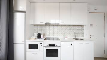 Een koelkast met diepvriezer, een microgolfoven, een oven, een kookplaat