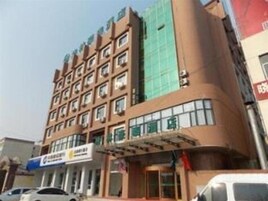 Un hotel de varios pisos con una entrada central y un área exterior cubierta.