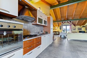 Een koelkast, een oven, een kookplaat, een eettafel