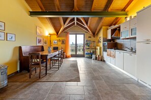 Een koelkast, een oven, een kookplaat, een eettafel