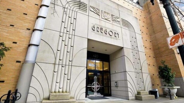 Un bâtiment dont la façade porte le nom « Gregory », caractérisé par un style architectural moderne, des motifs géométriques et une entrée imposante.