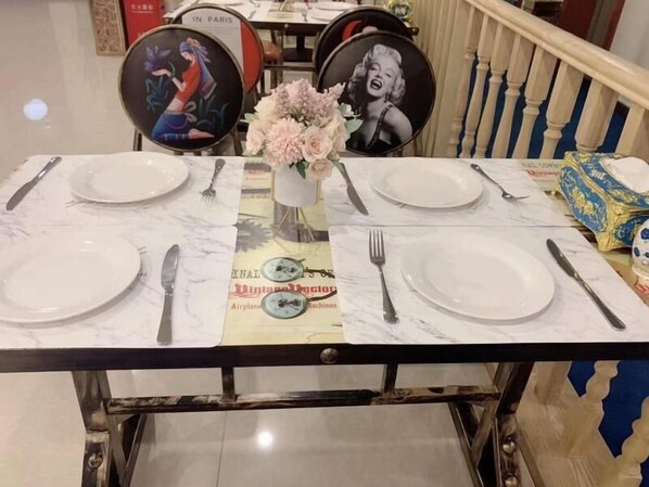 A dining table set with plates, cutlery, and a vase of flowers. - Shell Shanghai Songjiang District Xinqiao Town Xinqiao Hotel (Shanghai)