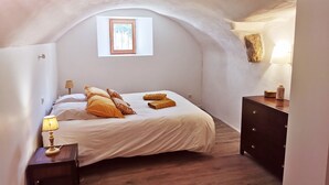 A bedroom with a bed, a nightstand, a dresser, and a window. - Cottage in a charming house (Vernoux-en-Vivarais)