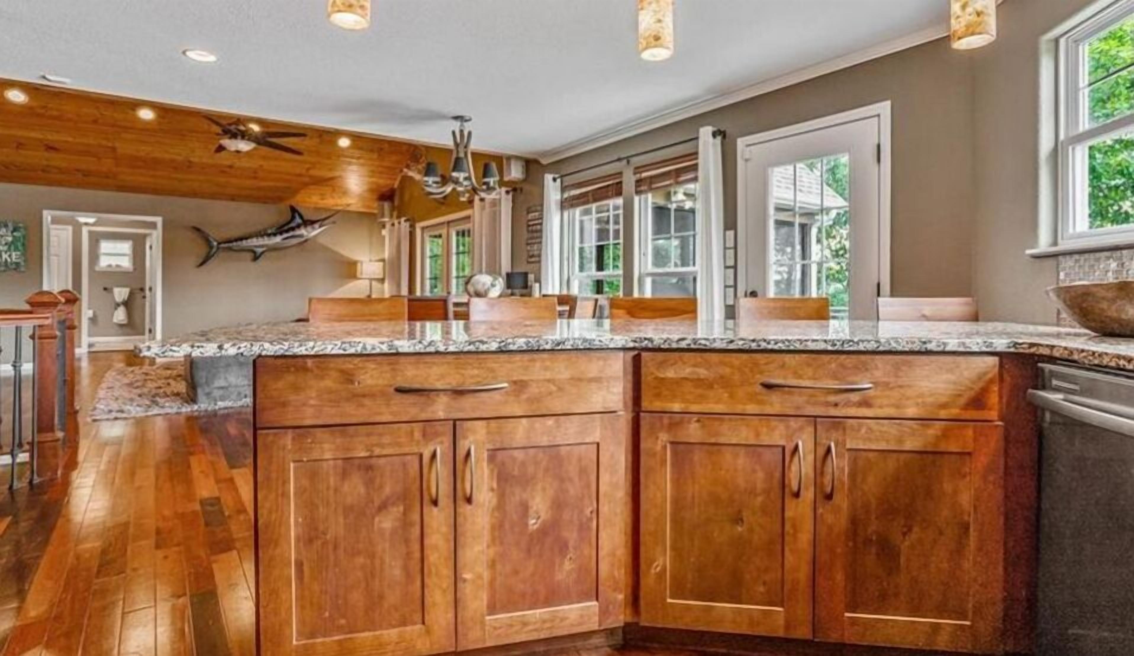 A spacious kitchen with wooden cabinets, granite countertops, and a large island.