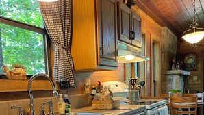 A wooden kitchen with a large island, stainless steel sink, and wooden cabinets. - Secluded yet within minutes of your favorite outdoor activities!! (Marshall)