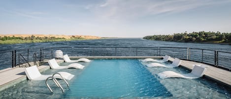 Una piscina al aire libre, tumbonas