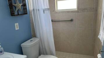 Een douche, handdoeken, toiletpapier