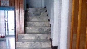 A staircase with stone steps leading upwards, flanked by wooden paneling and white walls. - Hotel Patria (Mexico City)