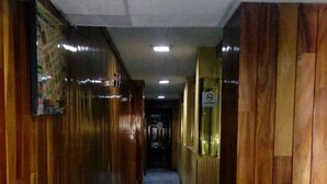 A hallway with wooden paneling on both sides and a tiled floor. - Hotel Patria (Mexico City)