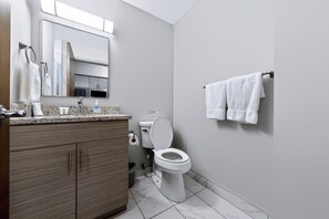 Et stilfuldt badeværelse med toilet, håndvask og underskab.