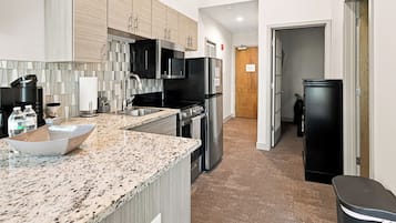 A modern kitchen with granite countertops, stainless steel appliances, and a tiled backsplash.