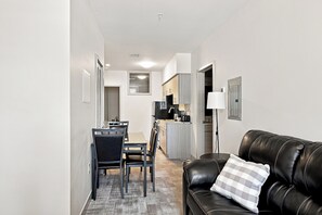 A modern living room with a leather sofa and a dining area with a table and chairs. - Downtown Historic Warehouse District Lofts 203 (Cleveland)