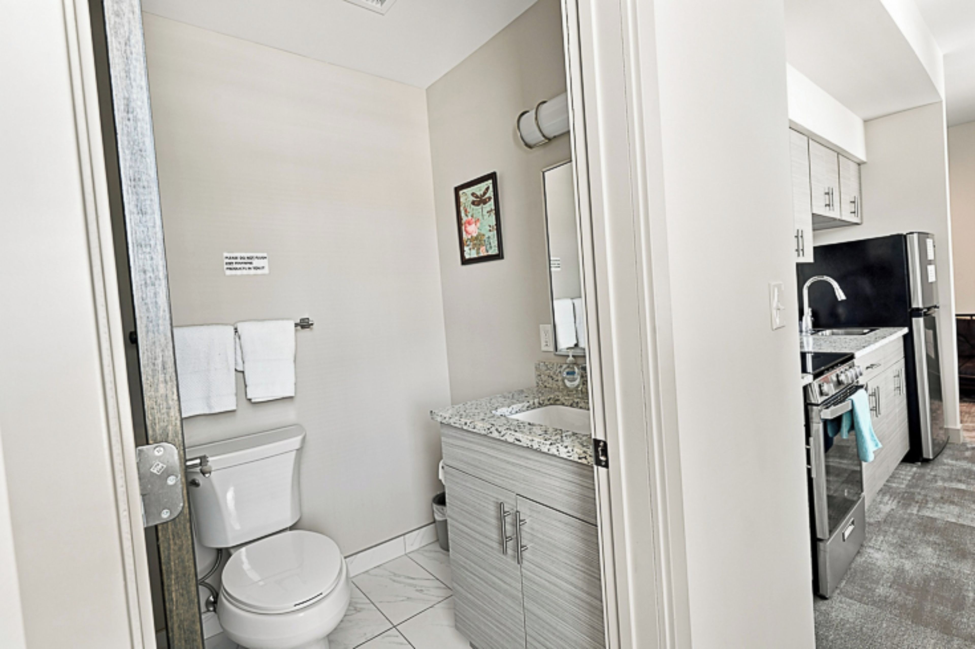 A bathroom with a toilet, sink, and cabinet.