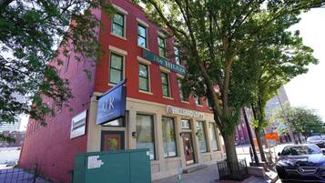 A red brick building with a storefront named 'HILLIARD LOFTS' and a sign for 'KUR' above it.