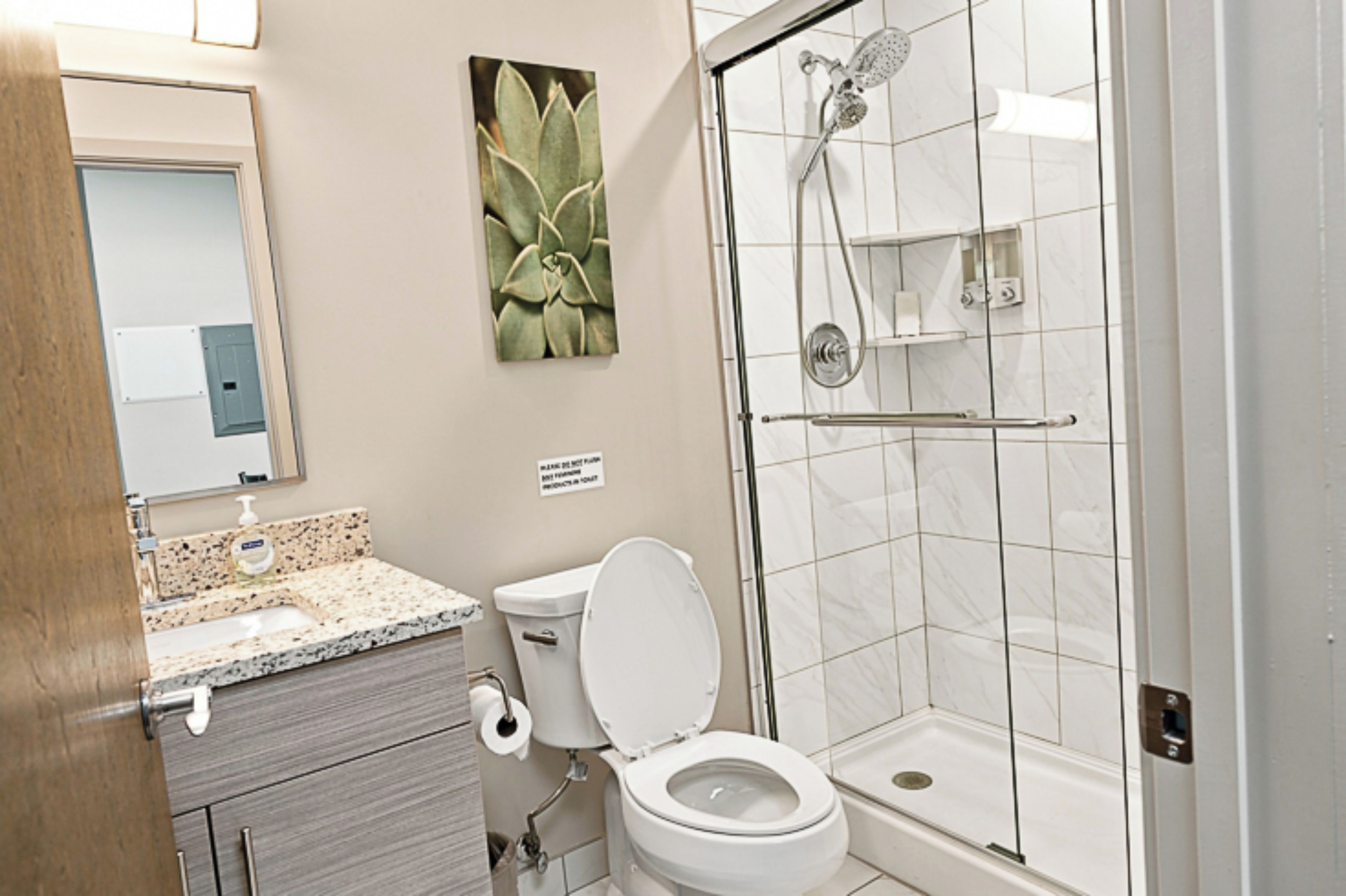 A bathroom with a toilet, sink, and shower.