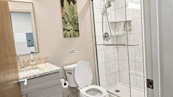 A bathroom with a toilet, sink, and shower.