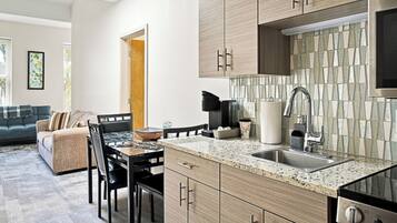A modern kitchen with granite countertops, stainless steel appliances, and wooden cabinetry.