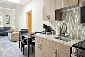 A modern kitchen with granite countertops, stainless steel appliances, and wooden cabinetry. - Downtown Historic Warehouse District Lofts 309 (Cleveland)