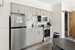 A modern kitchen with stainless steel appliances, a microwave, and a built-in oven. - Downtown Historic Warehouse District Lofts 307 (Cleveland)