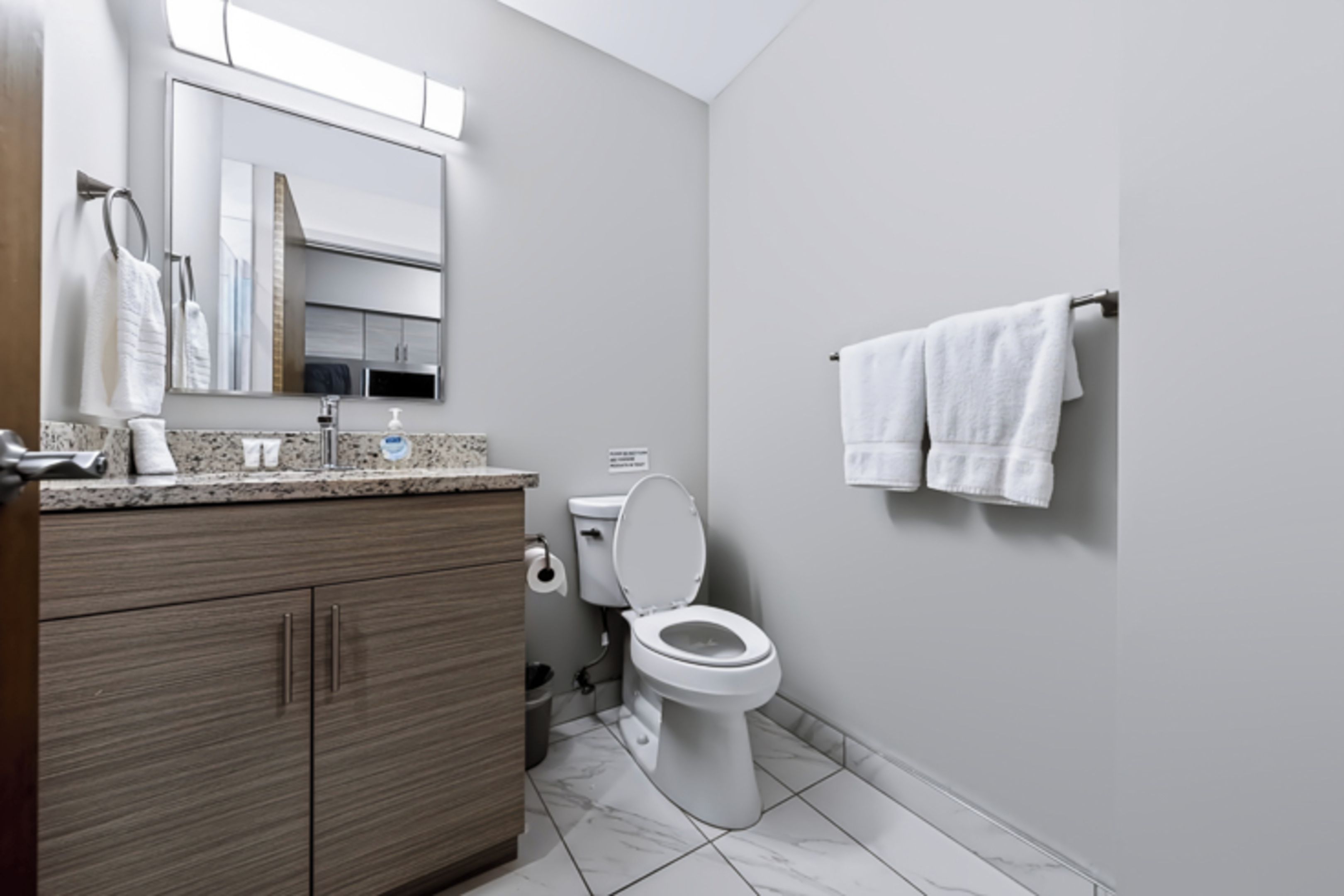 Un baño moderno con inodoro, lavamanos y tocador.