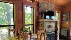 Un intérieur en bois avec une cheminée en pierre, un téléviseur et un tableau représentant un renard.