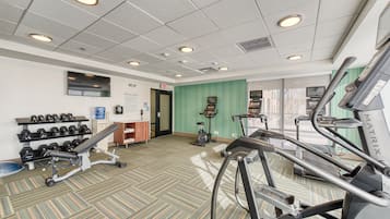 A gym with treadmills, dumbbells, and exercise equipment.