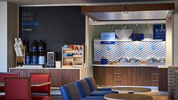 Uma cafeteria moderna com mesas, balcão de café e um quadro de cardápio.