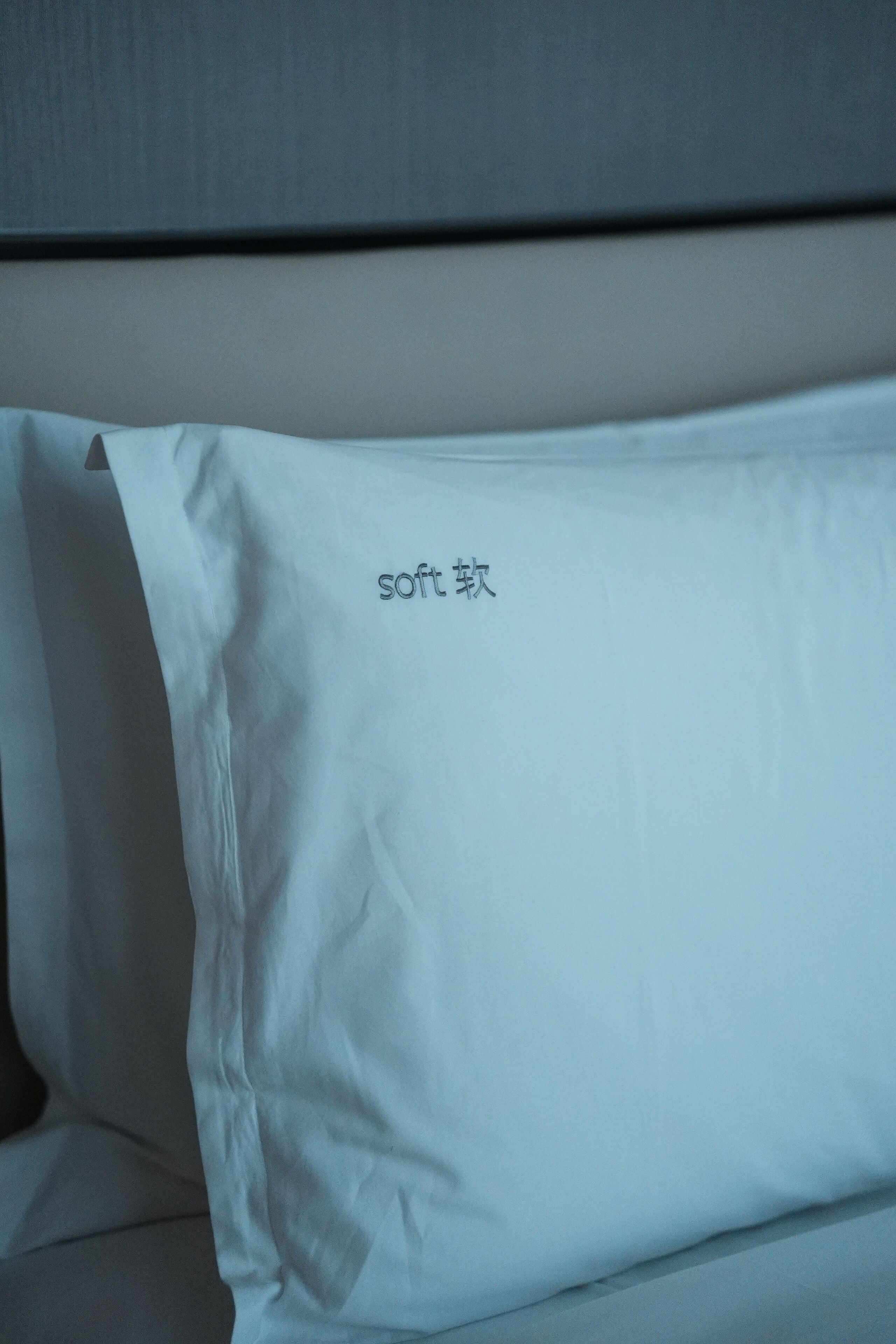 Almofada branca com a inscrição 'cama macia'.