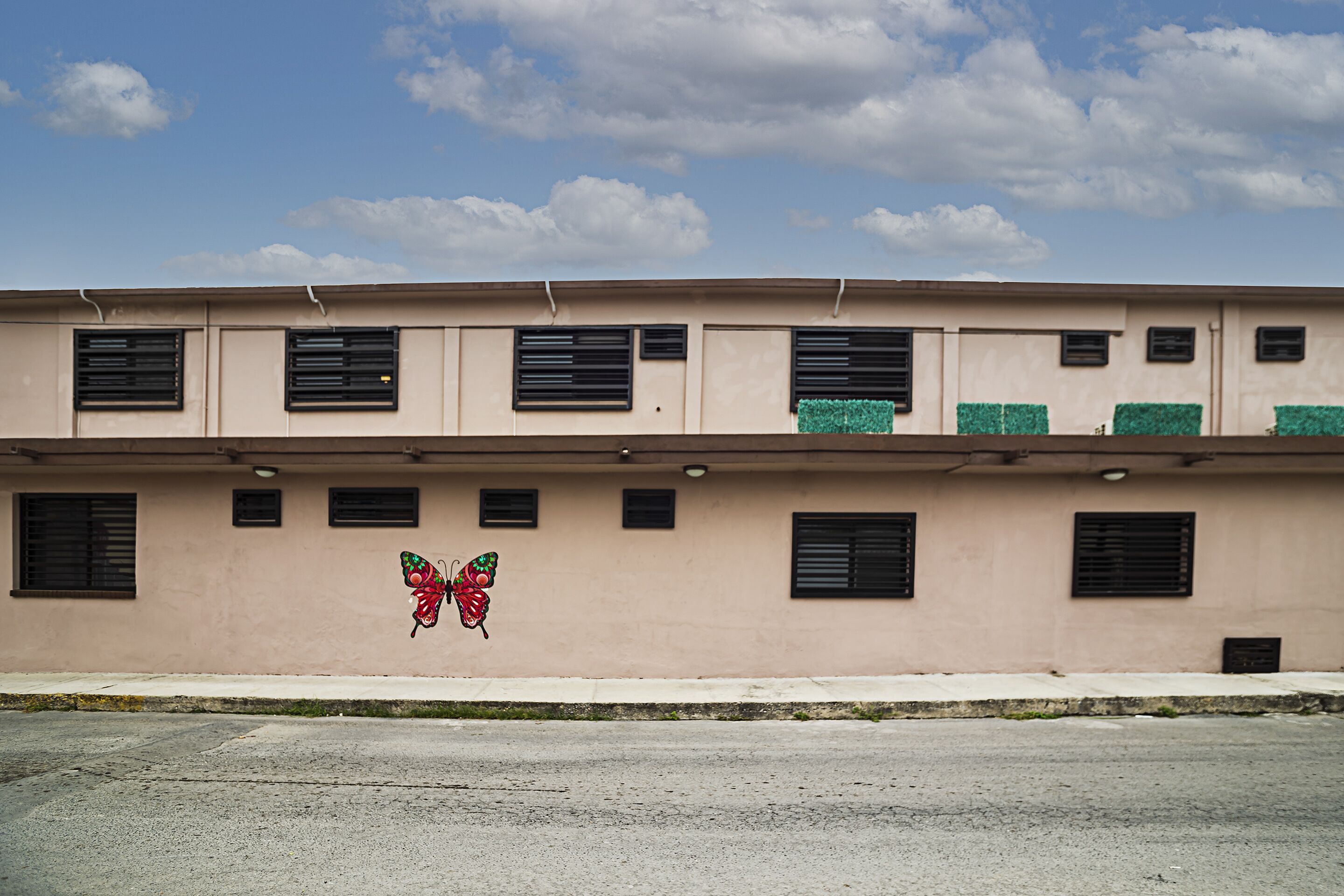 A building with multiple windows and a butterfly mural on the wall.
