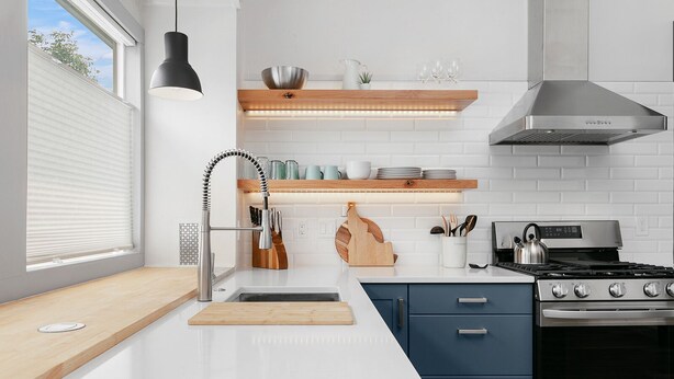 Eine moderne Küche mit einem Edelstahlherd, einem eingebauten Backofen, einer doppelten Spüle und Holz-Arbeitsplatten.