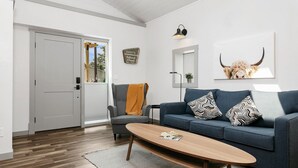 Ein modernes Wohnzimmer mit einem grauen Sofa, einem Holztisch und einem grauen Sessel.