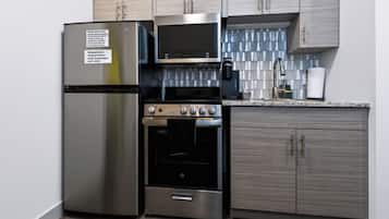 A kitchen with stainless steel appliances, including a refrigerator, microwave, and oven.