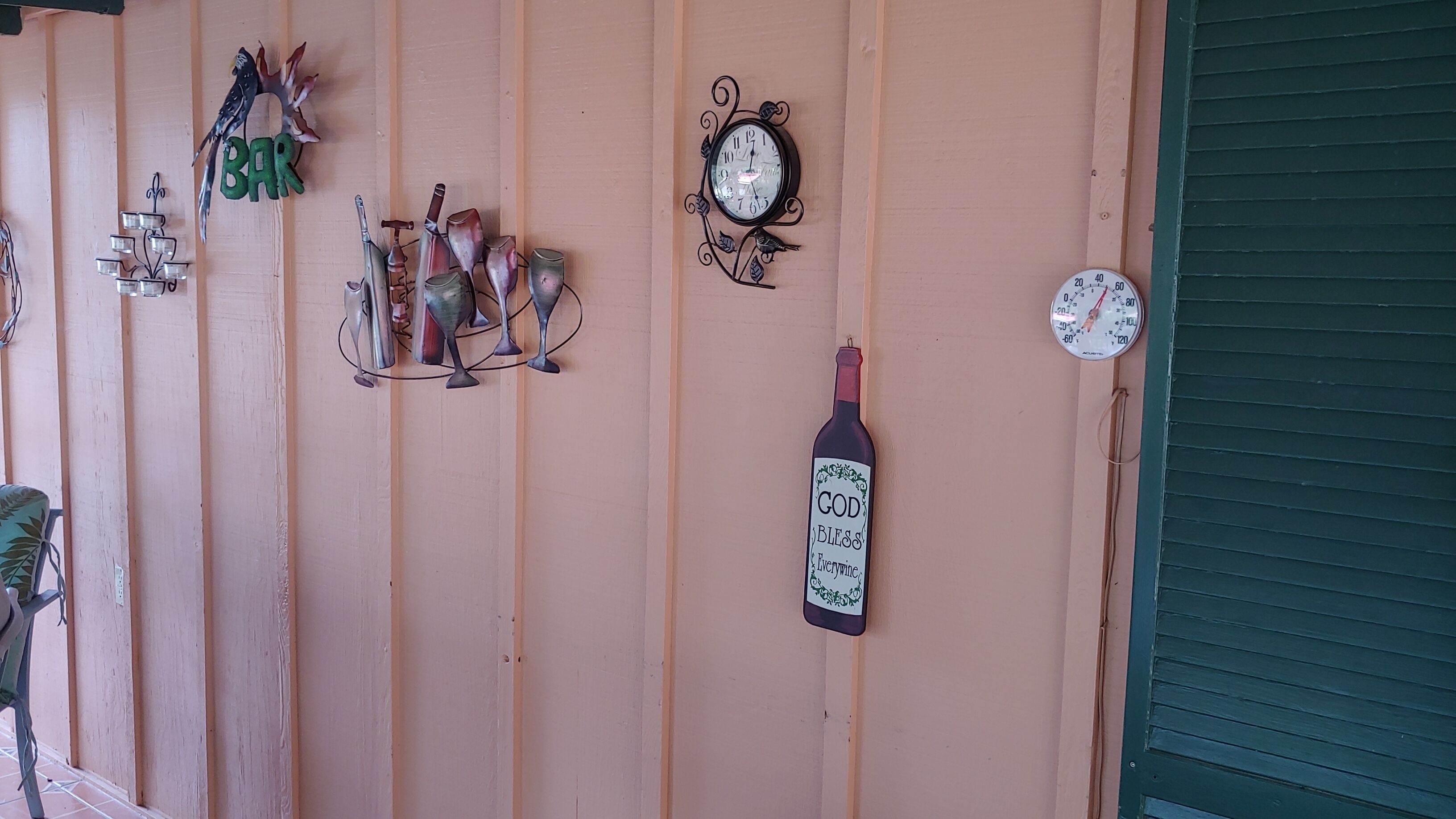 A wall with various decorative items including a clock, a wine bottle, and bird figurines.