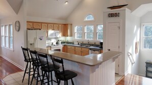 A spacious kitchen with a large island, wooden cabinets, and a built-in oven. - Corolla Light Resort! Dogs! Heated Pool! Hot tub! Walk to restaurants! C1131 (Corolla)