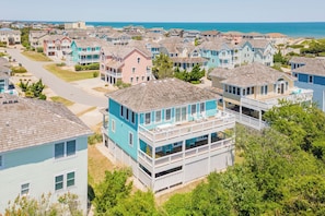 A coastal residential area with houses featuring balconies and a view of the ocean.