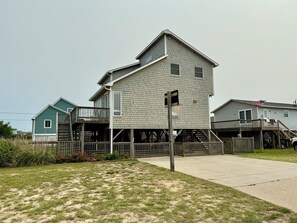 A two-story building with a balcony, a flag, and a wooden fence.