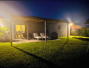 Relax in style on the covered patio, complete with comfortable seating and a small table.