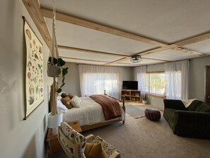 A bedroom with a large bed, a TV, a sofa, and a window with curtains. - Mountain Cabin Beautiful Views, near Nederland, Eldora Mt & Black Hawk, Colorado (Black Hawk)