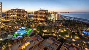 Un complexe hôtelier comprenant plusieurs bâtiments, un espace piscine et offrant une vue sur la plage.